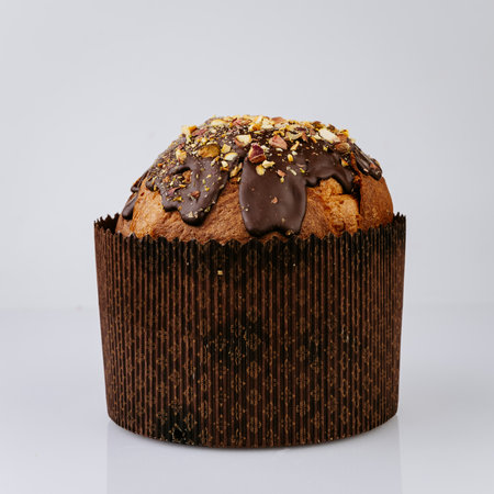Panettone with chocolate glaze and nuts on white background, festive dessertの写真素材
