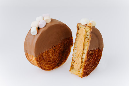 Chocolate-covered croissant roll with mini marshmallows on white backgroundの写真素材