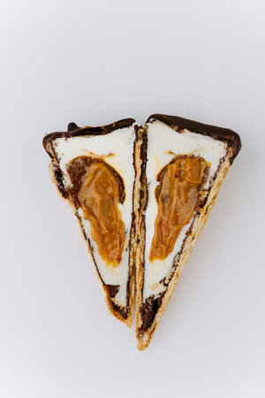 Sliced vanilla ice cream cone with caramel filling and chocolate coating on white backgroundの写真素材