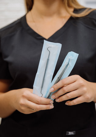 Sterile dental tools in sealed pouches held by clinician in modern clinicの写真素材