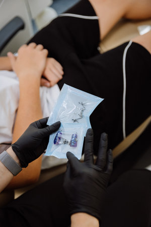 Orthodontist shows palatal expander in sterile pouch to patient, modern clinic