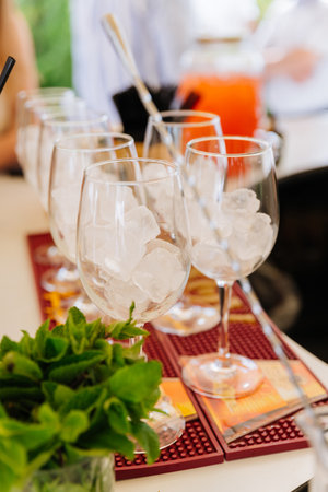 Wine glasses packed with ice and fresh mint on a bar, cocktail prep at a summer eventの写真素材
