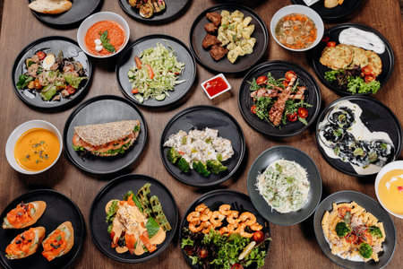 Assorted restaurant dishes on a wooden table, overhead flat lay of a catering menuの写真素材