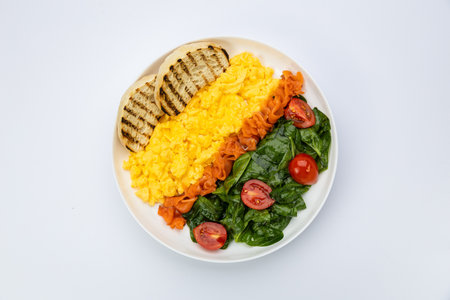 Scrambled eggs with smoked salmon, sauteed spinach and toast, studio top view