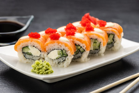 Salmon sushi rolls with cream cheese, red roe, soy sauce, wasabi and ginger, top viewの写真素材