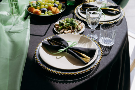 Elegant green and black restaurant tablescape with candelabra and gold accents