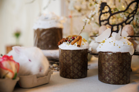Easter cakes with icing, spices and white bunny, cozy spring still life