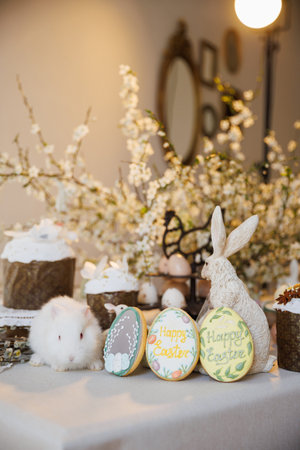 Easter still life with white bunny, Happy Easter cookies and spring blossoms