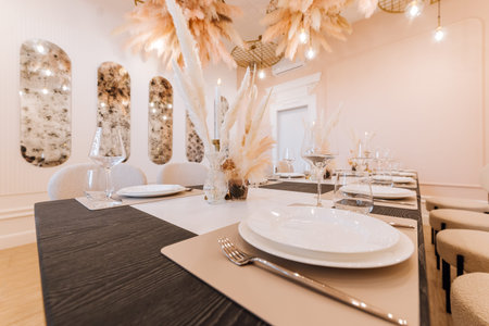 Elegant private dining table with pampas centerpieces, candles and modern tableware