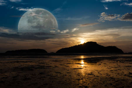 Super Moon, Sunrise on the island, tide down the beach as far as the eye can see, silhouettes.の写真素材