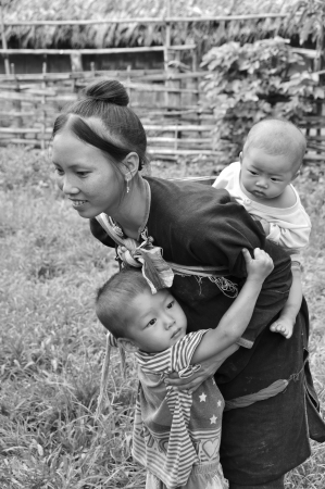 BOKEO,LAO PDR-JULY 21,2011 LANTAEN teen mom carries her kids on  July 21,2011 in Nam chang village, Bokeo province, Lao pdrのeditorial素材