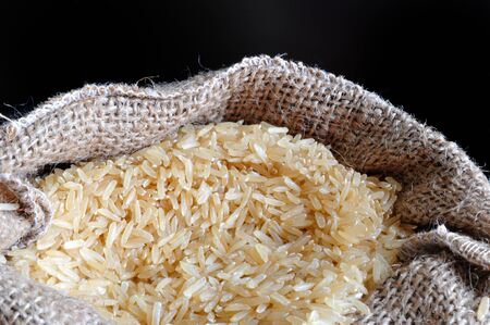 brown organic rice in burlap sack
