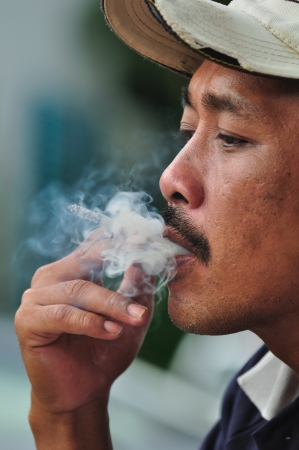 close up asian man smoking cigarette  の写真素材