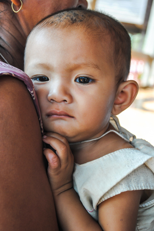 ALAVAN, LAO PDR  FEBRUARY 09 ;Unidentified child is on the arm of mother at the villagers meeting on February 9,2010 Salavan province ,Lao Pdr のeditorial素材