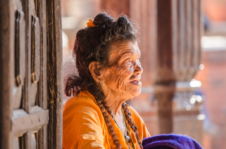 KATHMANDU, NEPAL - DECEMBER 04  An elderly woman sits at the gate of the Social welfare center Briddhashram  Elderly s home  on December 04, 2013 in Kathmandu, Nepalのeditorial素材