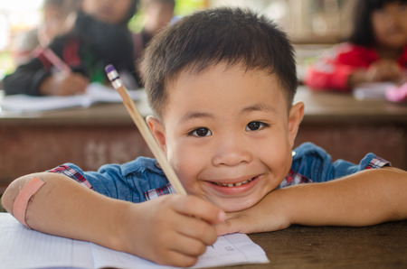 KAP CHOENG,SURIN,THAILAND-JULY 20  Unidentified happy Khmer kid is trying to write khmer character in classroom at Chong Jom market  Thai-cambodia border  on July 20,2014 in KapChoeng, Surin,Thailand のeditorial素材