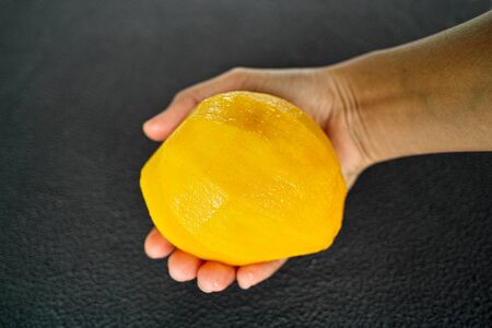 hand with mango isolated on black backgroundの写真素材