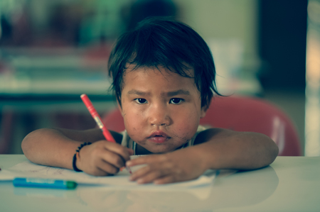 CHIANG DAO,CHIANG MAI,THAILAND-MARCH 16: Unidentified Palaung kid is trying to paint in class room at Pang Daeng Nok village on March 16,2015 in Chiang Dao,Chiangmai,Thailandのeditorial素材