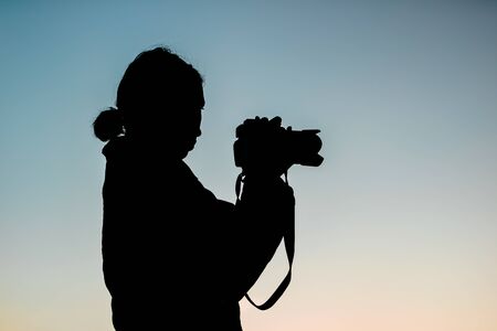 silhouette of a woman with cameraの写真素材