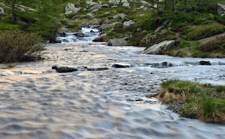 colorful reflections on the waters of the stream, at first light.