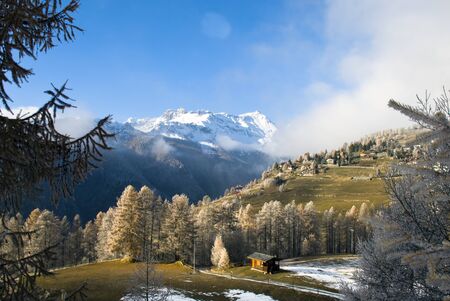 Alpine scenery with snow, fog and the blue sky