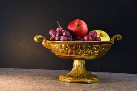The ceramic fruit bowl on a dark background.の写真素材
