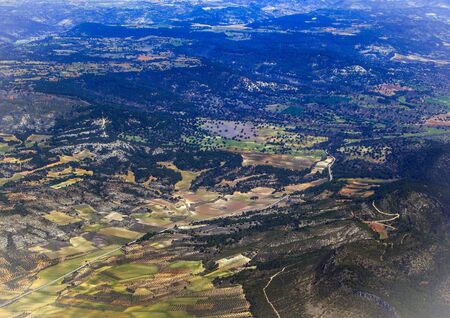 Top view of the ground from the plane. European landscape. Colorful pattern of trees, fields, rivers...