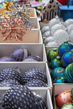 Christmas decoration. Red, yellow, blue and pink glass balls are in boxes in the store.の写真素材