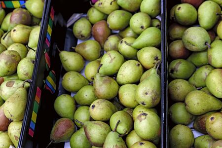 Seasonal fruits are placed in boxes in the grocery store. Close-up of fresh pears. Natural foods...