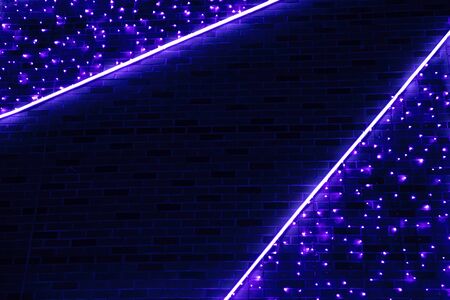 Neon blue light against the background of a brick wall. Abstract background of deep blue color.の写真素材