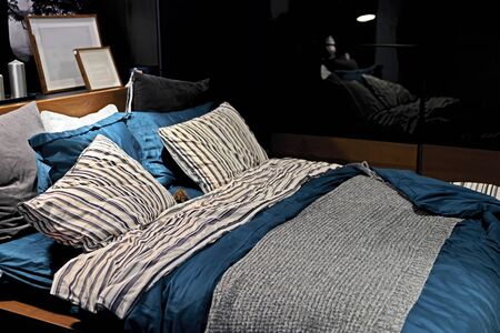 A cozy bed with soft pillows is shot close-up. Blurred background.