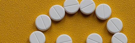 Trendy pattern made with Pharmaceutical medicine pills, tablets and capsules on bright light yellow...