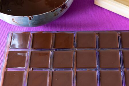 The molds are filled with liquid chocolate mass. The process of home cooking healthy sweets without sugar.の写真素材