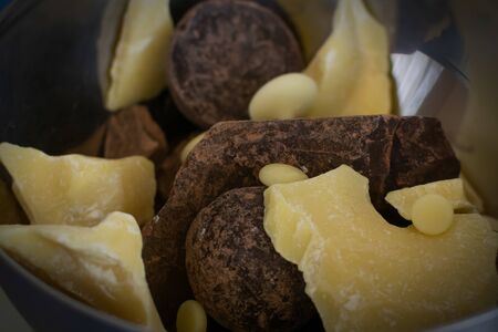 Broken pieces of dark bitter chocolate and white milk chocolate. Ingredients for home cooking of healthy sweets without sugar.の写真素材