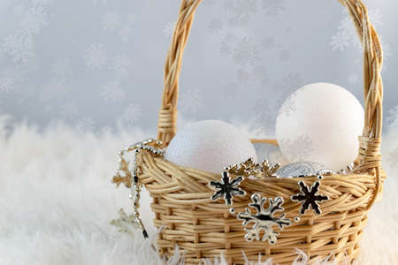 silver and white Christmas balls in a basket that stands on a fluffy fur blanket. Copy space for your congratulations textの写真素材