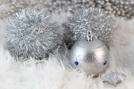 Poster with silver Christmas balls. Beautiful Christmas composition with copy space on a fluffy white fur background.の写真素材