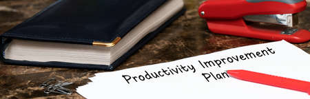 productivity improvement plan on the table next to the red pen. Drawing up a plan to increase the number of completed tasksの写真素材