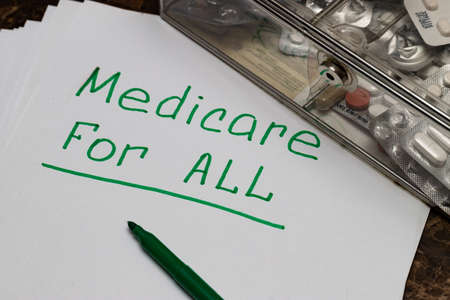 The Medicare for all sign is written on the sheet in green letters, next to the pills.の写真素材