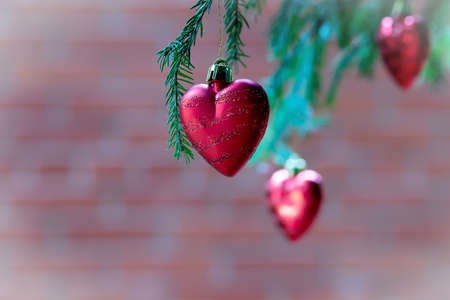 Red heart on christmas tree as holiday decoration. Merry christmas and happy new year greeting card.