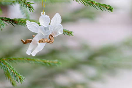 figurine of an angel on a christmas tree. Merry christmas and happy new year greeting card.
