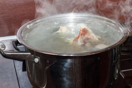 Cooking meat for broth in a saucepan in the kitchen. The recipe for cooking Ukrainian borscht.の写真素材