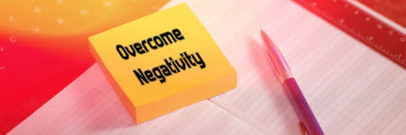 Overcome Negativity. The text is written on a yellow sticky note that lies on the table. Selective...
