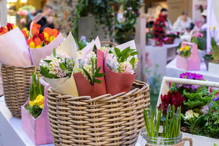 Sale of flowers for the spring holidays. Bouquets of hyacinths wrapped in paper in a wicker basket...