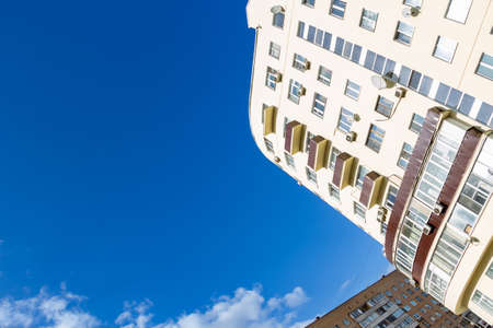 Houses on a blue sky background with white clouds of early spring. Clear very bright sky.の写真素材