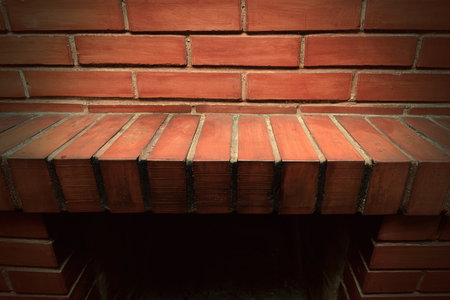 Empty red brick mantel. Backdrop of a brick fireplace wall in a vacant settingの写真素材