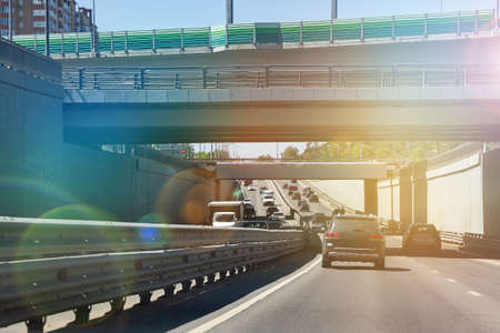 Road scenery on a highway at summer time. A toned image of a cityscape. Car traffic on the road in Moscow. The modern life of the big city.の写真素材