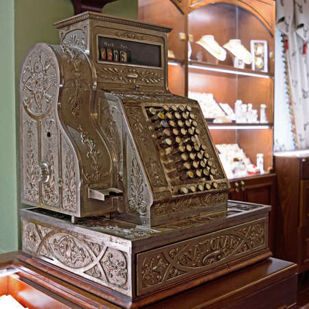 Old-time cash register in a shop. Old-fashioned German engraved metal cash register.の写真素材