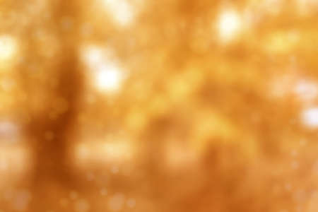 Blurred fall nature background in brown tones. Autumn foliage on trees over sun light in garden or park.の写真素材