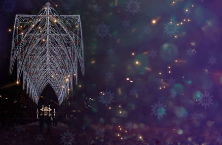 Festive illumination in the city for the New Year. The street is decorated for Christmas, a dark background with copy space. Mockup for postcard. New year in Russia. Sense of celebration.の写真素材