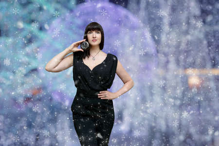 Festive christmas background with bright lights and a woman in a fashionable suit. Mockup for...